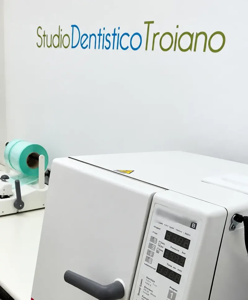 Autoclave e imbustatrice nell'area di sterilizzazione, con la scritta dello studio sulla parete